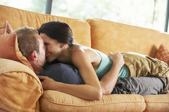 Romantic Couple Lying On Sofa At Home