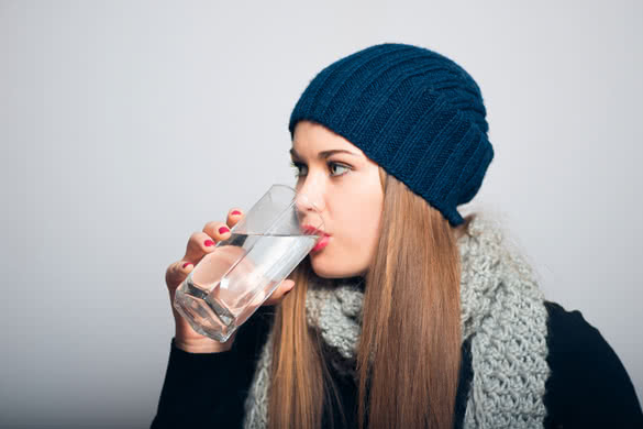 Winter girl drinking a glass of water