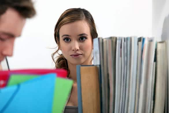 Woman gazing at a man in a library