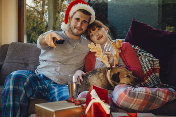 Young couple at home with their pet dog at Christmas time