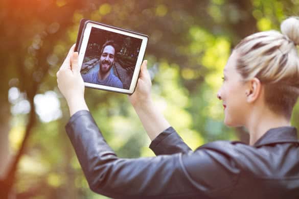 attractive modern young couple having a video call over a table