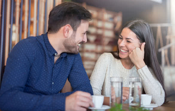 Beautiful loving couple sitting in a cafe enjoying in coffee and conversation
