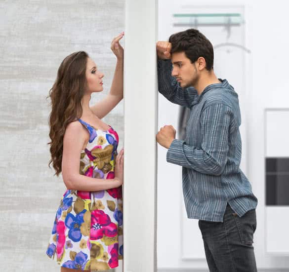 Conflict between man and woman standing on either side of a wall