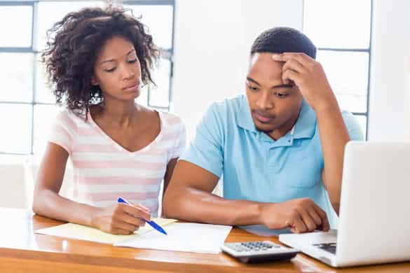 Worried young couple discussing bills at home