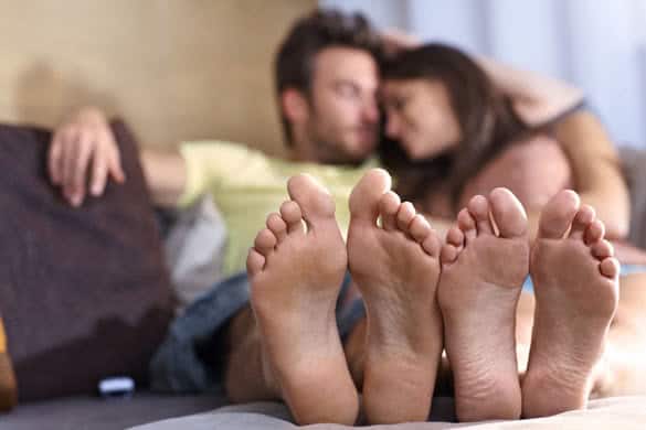 Young loving couple lying on sofa at home