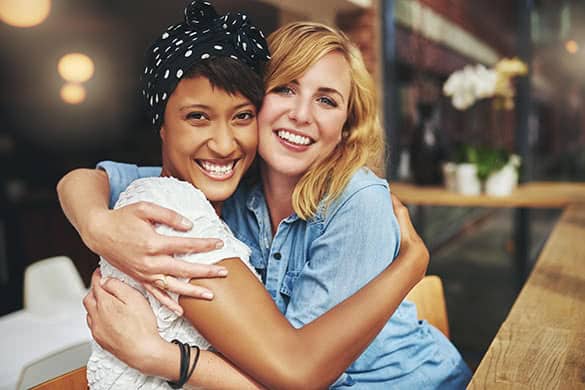 young friends hugging and smiling