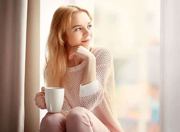 young blonde woman enjoying a cup of coffee