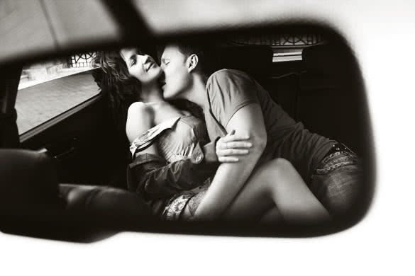 young lovers kissing in the car