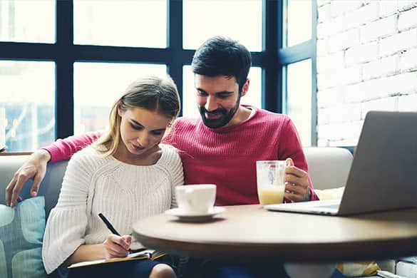 couple drinking cofffee and writing in a notebook